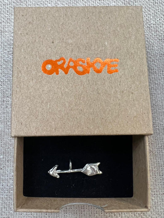 Silver arrow-shaped charm in a box with 'ORASKYE' branding.